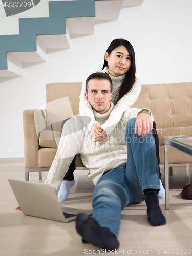 Image of happy multiethnic couple relaxing at home