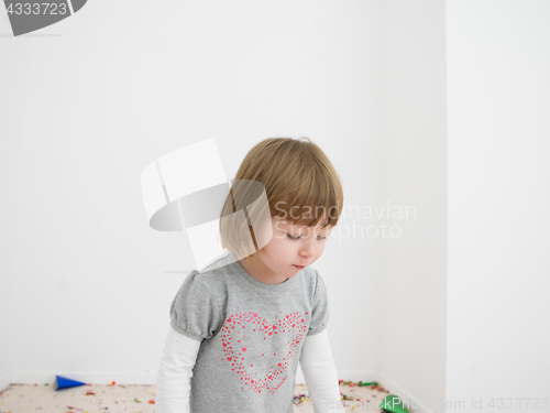 Image of Little girl standing on confetti