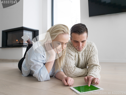 Image of Young Couple using digital tablet on cold winter day