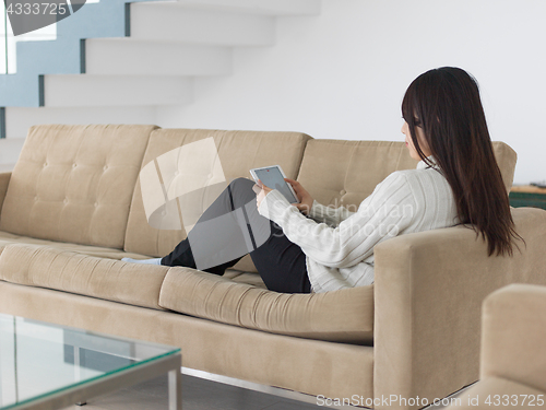 Image of asian woman using Digital Tablet on sofa