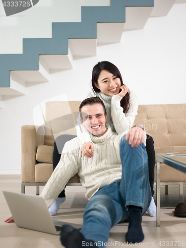 Image of happy multiethnic couple relaxing at home
