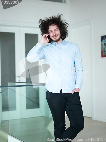 Image of man using a mobile phone  at home