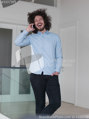 Image of man using a mobile phone  at home