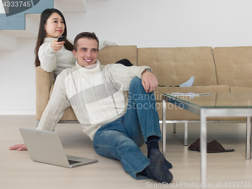 Image of multiethnic couple on the sofa watching television