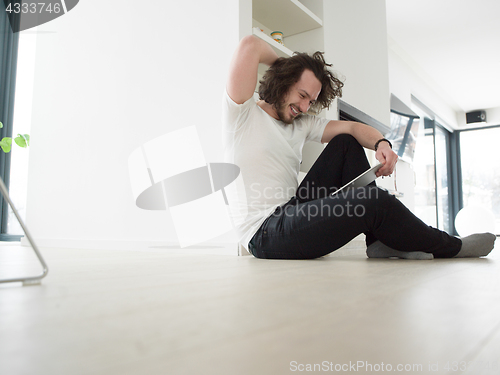 Image of young man using a tablet at home