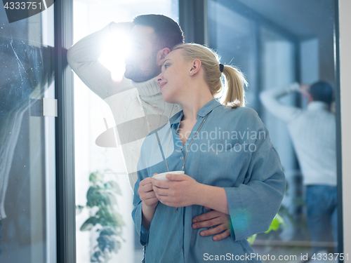 Image of young couple enjoying morning coffee by the window