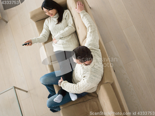 Image of multiethnic couple on the sofa watching television