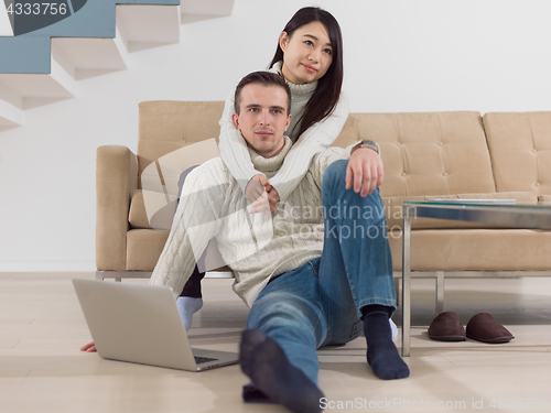 Image of happy multiethnic couple relaxing at home