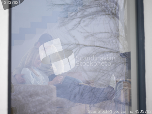 Image of Couple using digital tablet on cold winter day