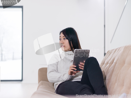 Image of asian woman using Digital Tablet on sofa