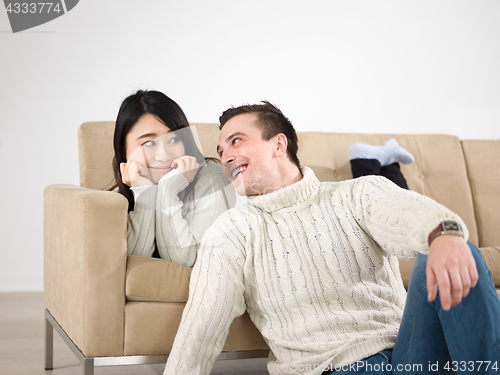 Image of happy multiethnic couple relaxing at home