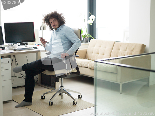 Image of man using a mobile phone  at home