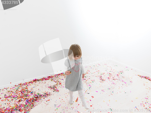 Image of Little girl standing on confetti