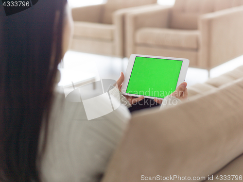 Image of asian woman using Digital Tablet on sofa