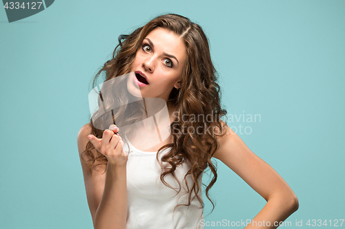 Image of Portrait of an angry woman looking at camera on a blue background