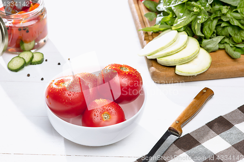 Image of Canned tomatoes and fresh tomato on white background