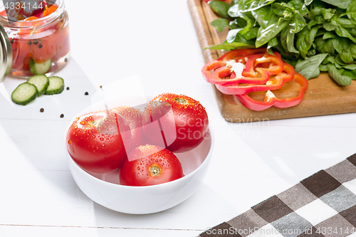 Image of Canned tomatoes and fresh tomato on white background