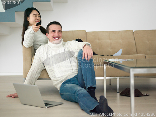 Image of multiethnic couple on the sofa watching television