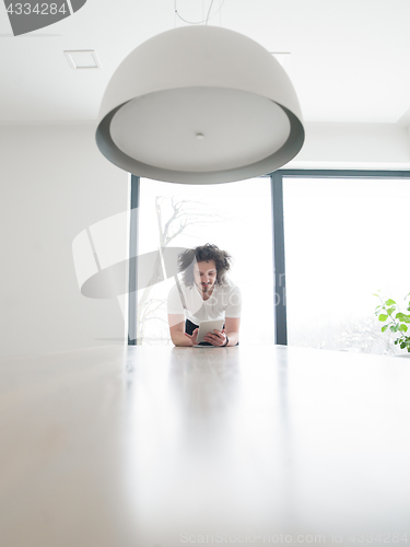 Image of young man using a tablet at home