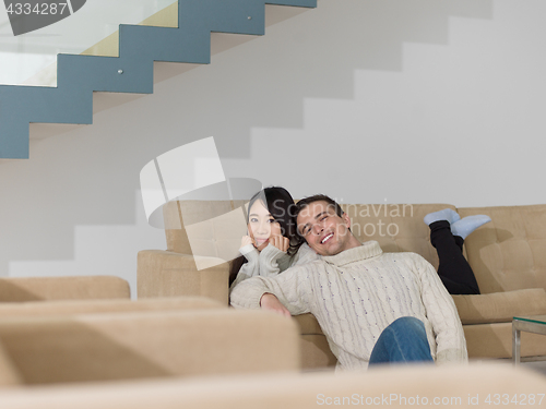 Image of happy multiethnic couple relaxing at home