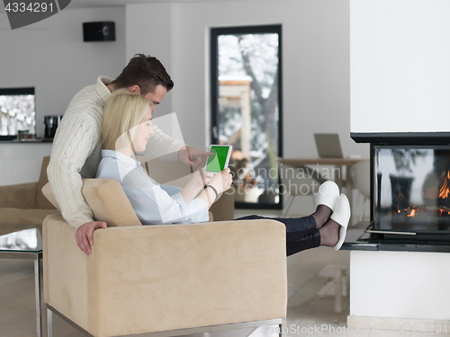 Image of Couple using digital tablet on cold winter day