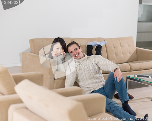 Image of happy multiethnic couple relaxing at home