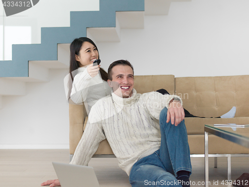Image of multiethnic couple on the sofa watching television