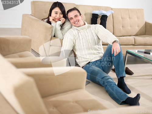 Image of happy multiethnic couple relaxing at home