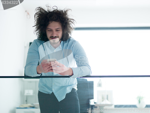 Image of man using a mobile phone  at home