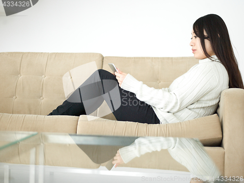 Image of asian woman using Digital Tablet on sofa