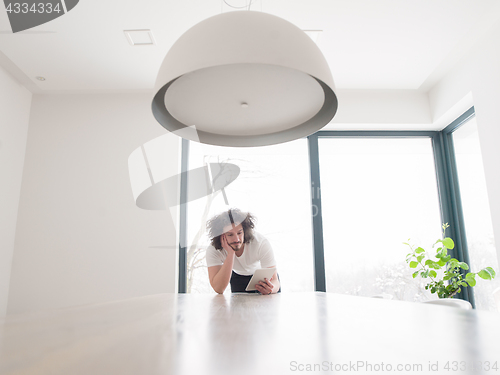 Image of young man using a tablet at home