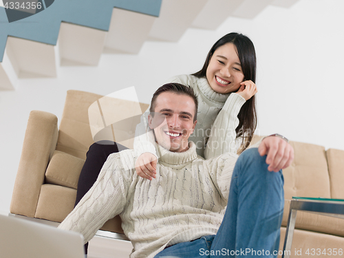 Image of happy multiethnic couple relaxing at home