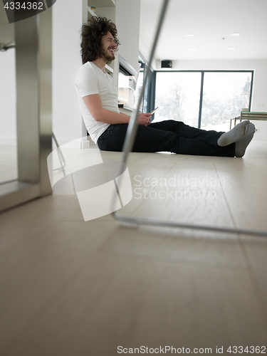 Image of young man using a tablet at home