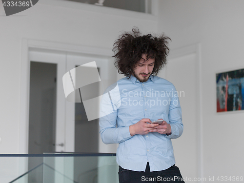 Image of man using a mobile phone  at home