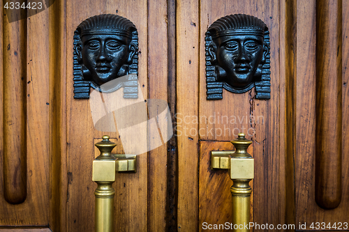 Image of Sphinx heads entrance on wooden door