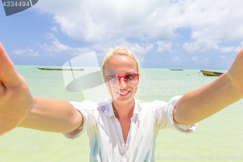 Image of Beautiful young woman doing selfie on tropical beach.