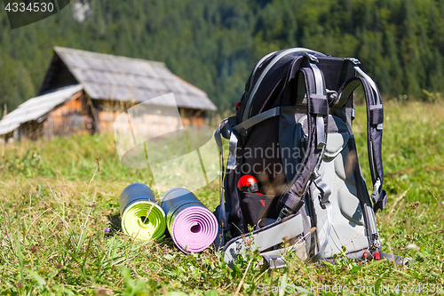 Image of Backpack and yoga mats on mountain meadow.