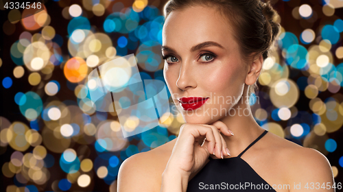 Image of beautiful woman in black over lights background