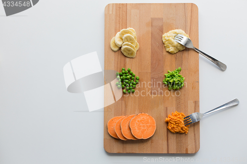 Image of mashed fruits and vegetables with forks on board