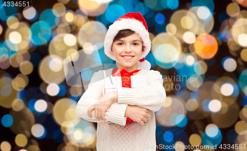 Image of smiling happy boy in santa hat with christmas gift