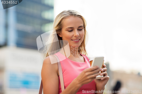 Image of woman with coffee and smartphone in city