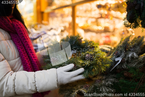 Image of woman with fir tree wreath at christmas market