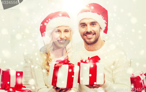 Image of happy couple at home with christmas gift boxes