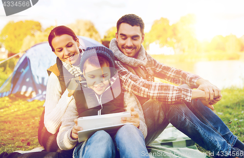 Image of happy family with tablet pc and tent at camp site