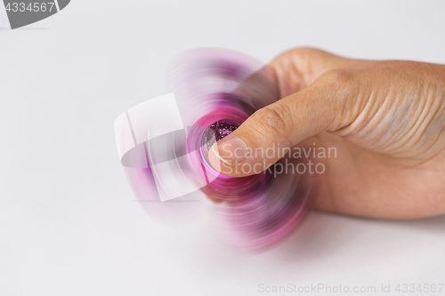 Image of close up of hand playing with fidget spinner