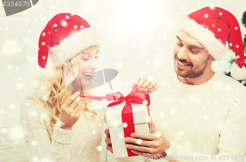 Image of happy couple at home with christmas gift box