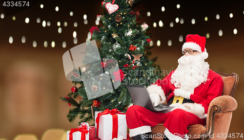 Image of man in costume of santa claus with laptop