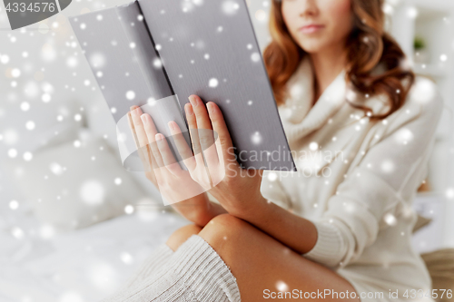Image of close up of young woman reading book at home