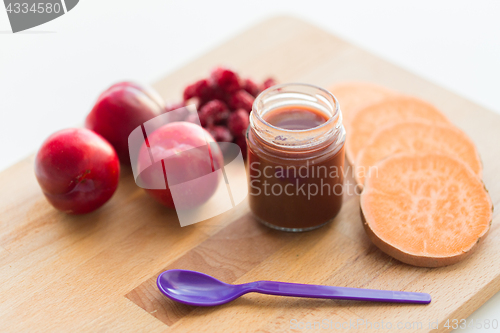 Image of fruit puree or baby food in jar and feeding spoon