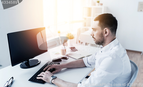 Image of businessman typing on computer keyboard at office